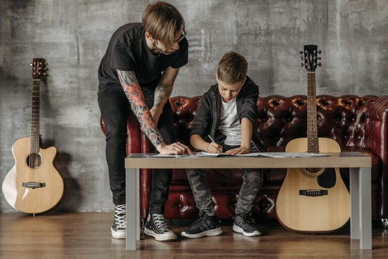 A young boy learning guitar with an instructor in a modern studio setting.